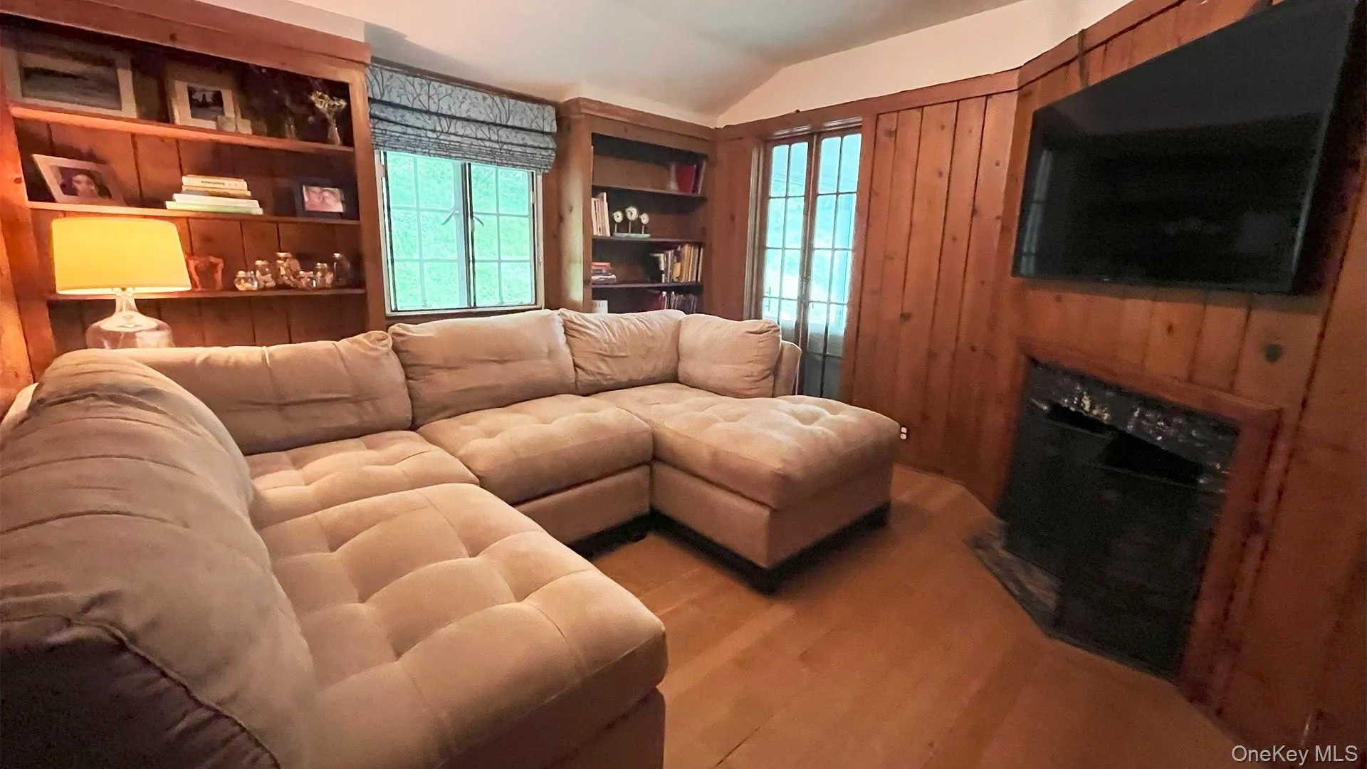Cosy paneled TV room with fireplace and hardwood floors Cosy paneled TV room with fireplace and hardwood floors