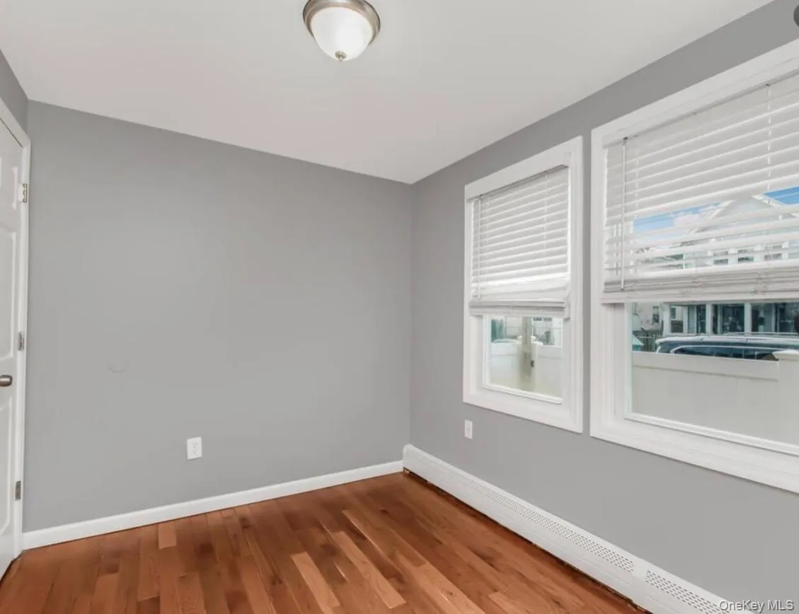 Empty bedroom with a baseboard radiator and wood finished floors Empty bedroom with a baseboard radiator and wood finished floors