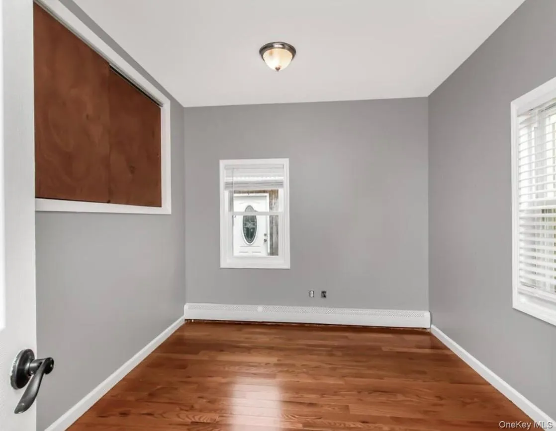 Empty bedroom featuring wood finished floors and plenty of natural light Empty bedroom featuring wood finished floors and plenty of natural light