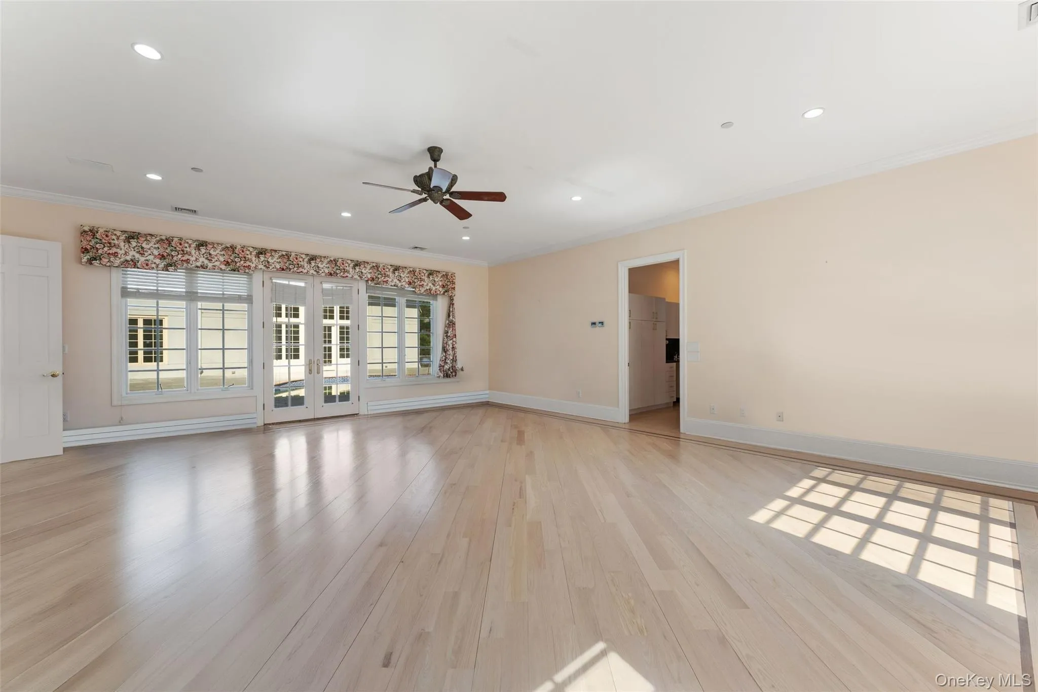 Primary bedroom featuring light wood-style floors, a ceiling fan, recessed lighting, and baseboard heating with a view of the pool Primary bedroom featuring light wood-style floors, a ceiling fan, recessed lighting, and baseboard heating with a view of the pool