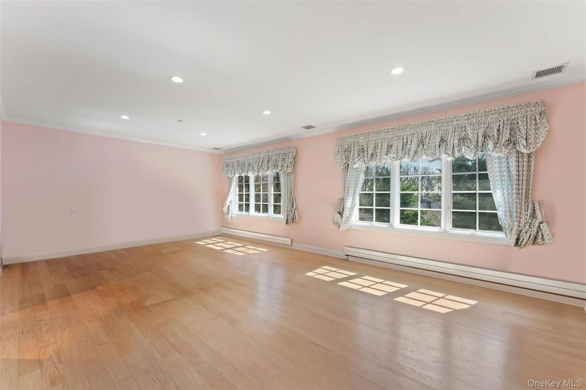 2nd floor bedroom featuring baseboard heating, light wood flooring, crown molding, recessed lighting, and a baseboard radiator 2nd floor bedroom featuring baseboard heating, light wood flooring, crown molding, recessed lighting, and a baseboard radiator
