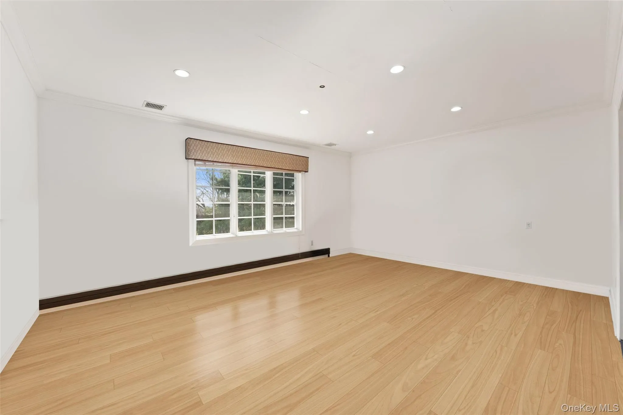 2nd floor bedroom featuring baseboard heating, light wood flooring, crown molding, recessed lighting, and a baseboard radiator 2nd floor bedroom featuring baseboard heating, light wood flooring, crown molding, recessed lighting, and a baseboard radiator