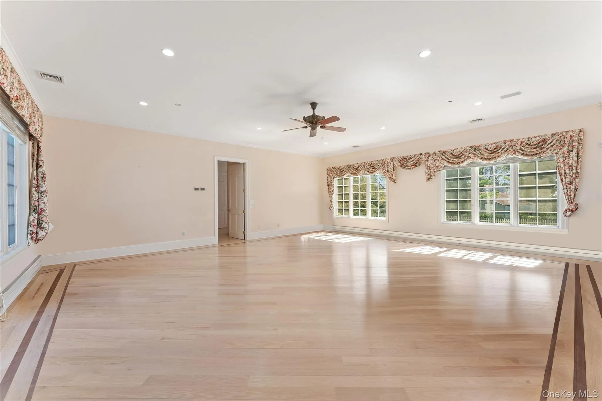 Primary bedroom featuring light wood-style floors, a ceiling fan, recessed lighting, and baseboard heating Primary bedroom featuring light wood-style floors, a ceiling fan, recessed lighting, and baseboard heating