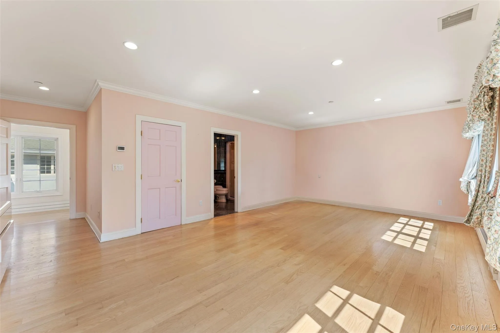 2nd floor bedroom featuring baseboard heating, light wood flooring, crown molding, recessed lighting, and a baseboard radiator 2nd floor bedroom featuring baseboard heating, light wood flooring, crown molding, recessed lighting, and a baseboard radiator