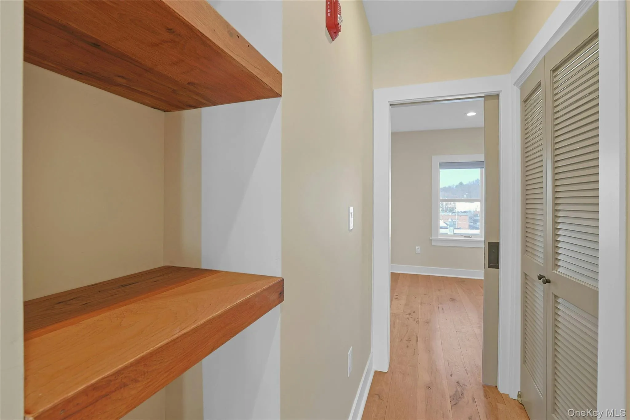 Custom shelves in hallway as you walk toward the sun-filled bedroom. Laundry behind the doors on your right. Custom shelves in hallway as you walk toward the sun-filled bedroom. Laundry behind the doors on your right.