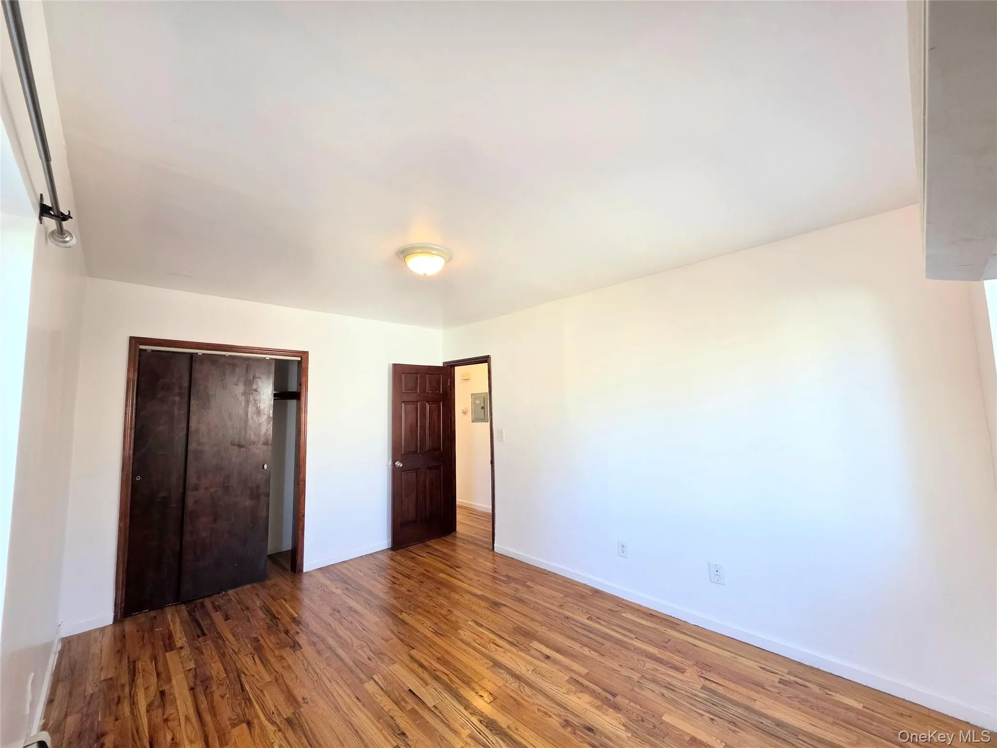 Unfurnished main bedroom featuring dark wood-style flooring and a closet. AC in room Unfurnished main bedroom featuring dark wood-style flooring and a closet. AC in room