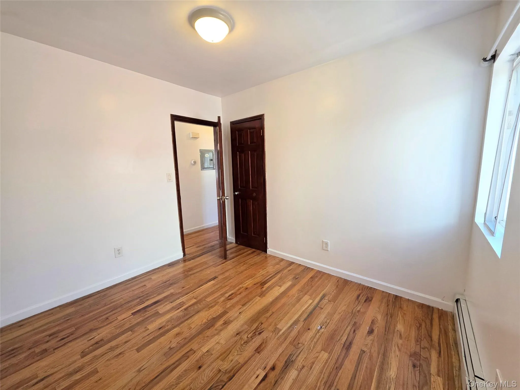 Unfurnished secondary bedroom featuring dark wood-style flooring and a closet. Unfurnished secondary bedroom featuring dark wood-style flooring and a closet.