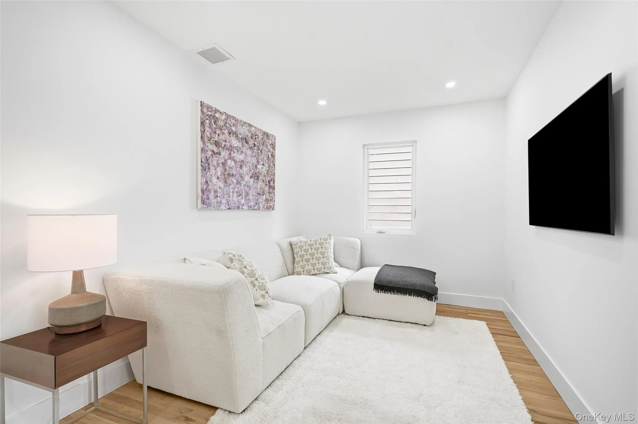 Living room featuring light wood-type flooring and recessed lighting Living room featuring light wood-type flooring and recessed lighting