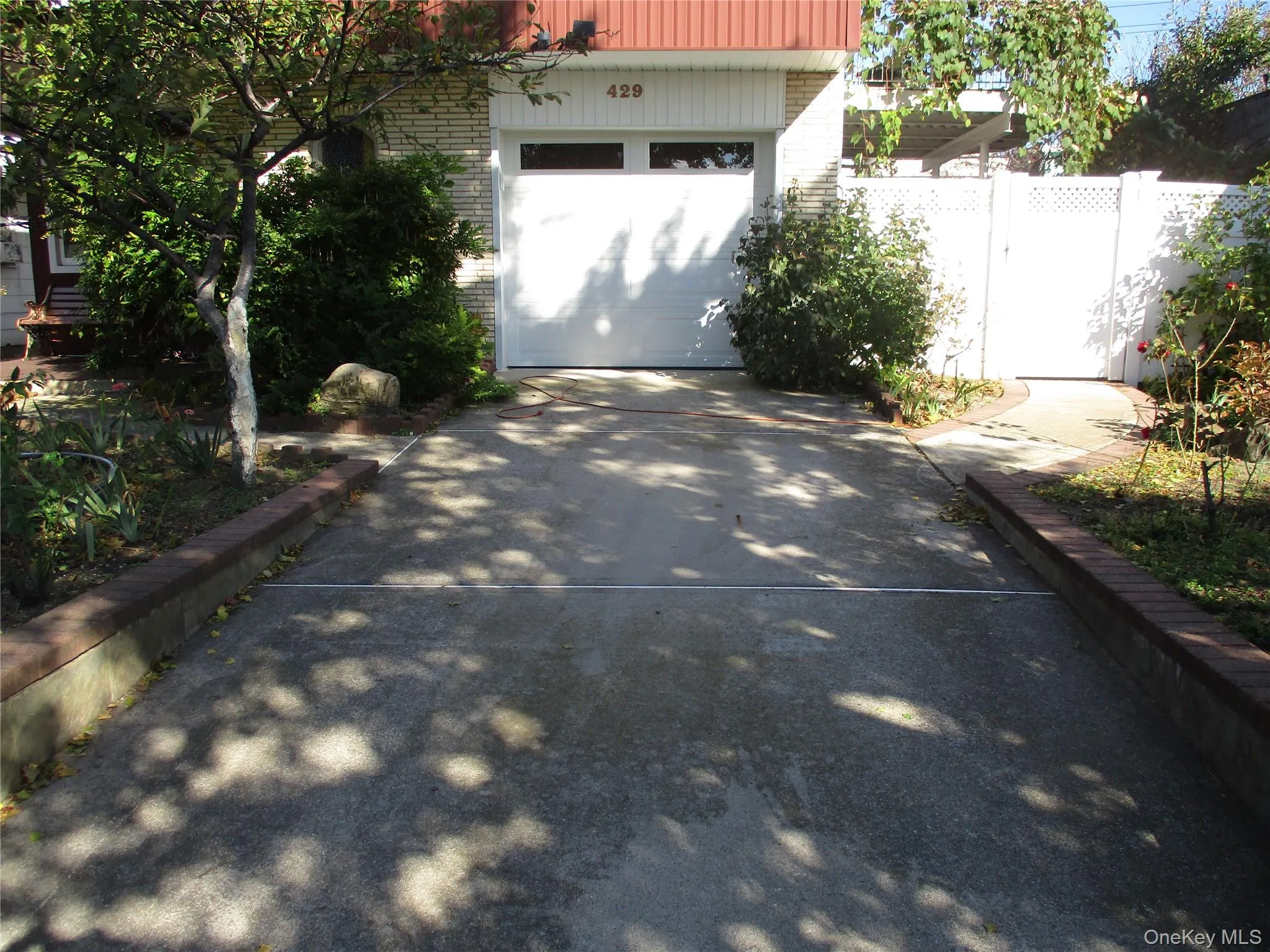 View of patio with driveway and a garage View of patio with driveway and a garage