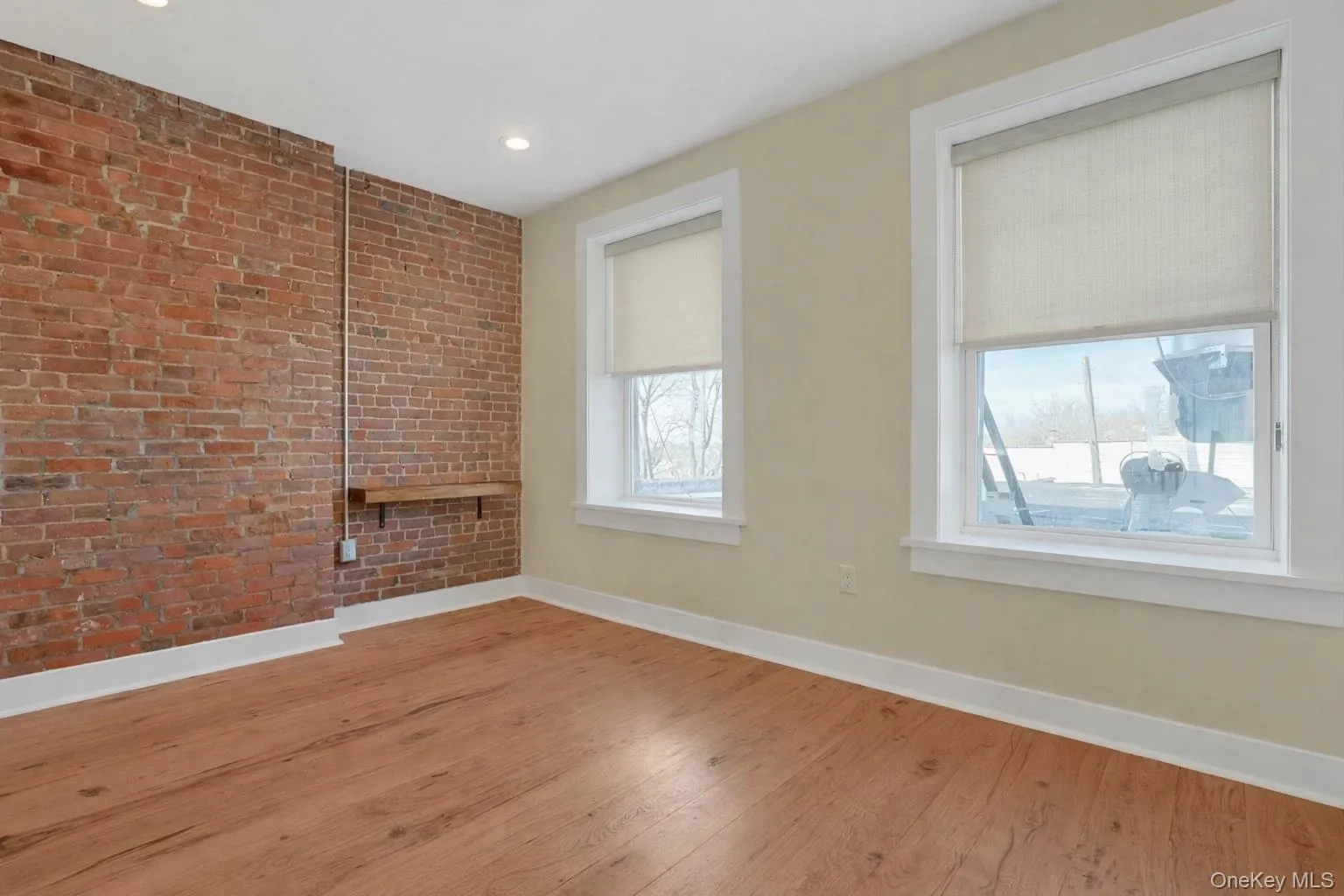 Light-filled bedroom with exposed brick walls and built in shelving. Light-filled bedroom with exposed brick walls and built in shelving.