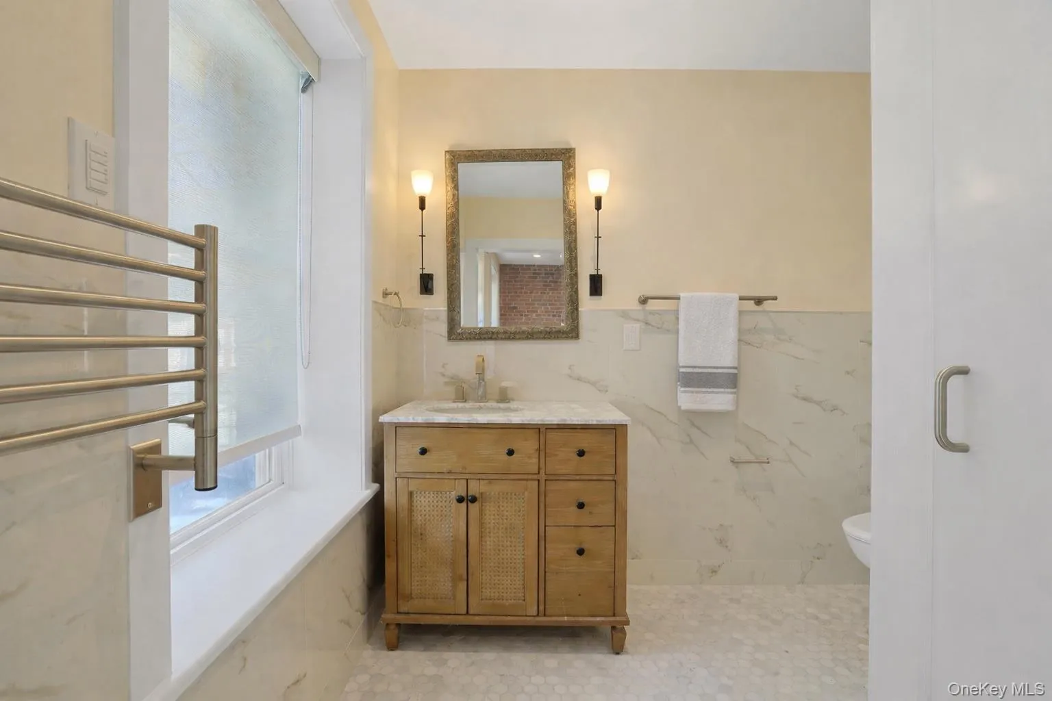 Sun-filled European-style en-suite bathroom with towel warmer. Sun-filled European-style en-suite bathroom with towel warmer.