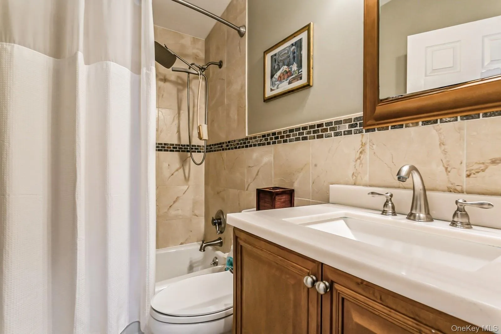 Full bath with toilet, shower / bathtub combination with curtain, tile walls, and vanity Full bath with toilet, shower / bathtub combination with curtain, tile walls, and vanity