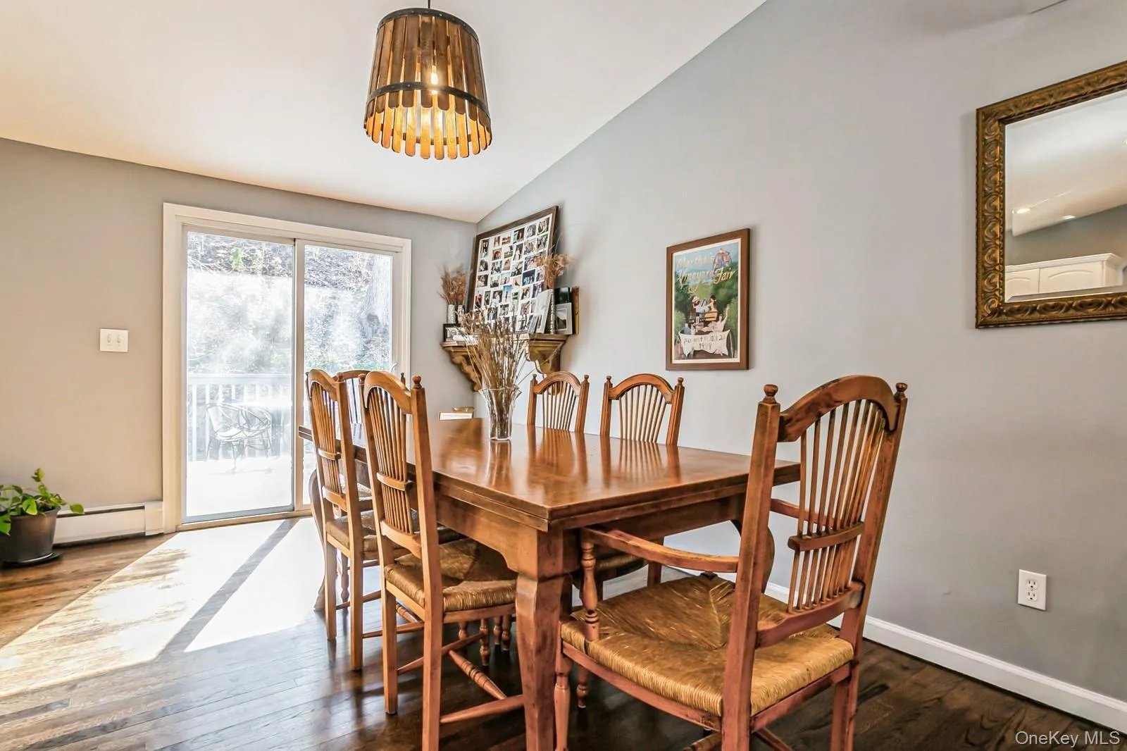 Dining room with baseboards, a baseboard heating unit, vaulted ceiling, and dark wood-type flooring Dining room with baseboards, a baseboard heating unit, vaulted ceiling, and dark wood-type flooring