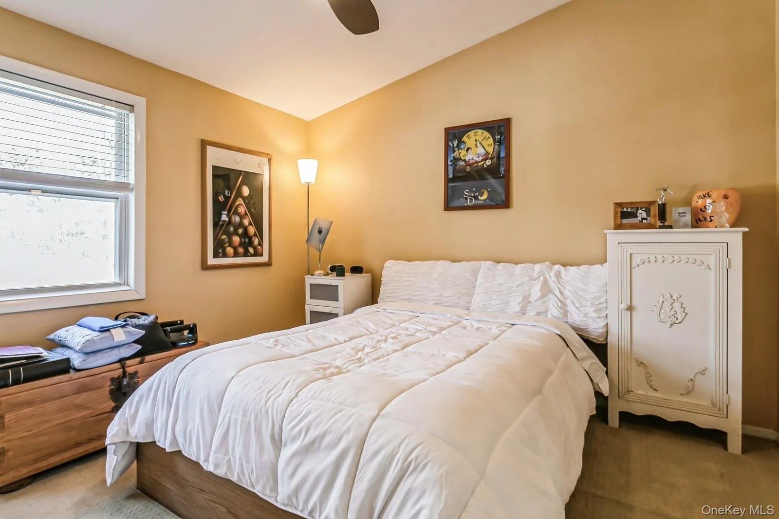 Carpeted bedroom featuring a ceiling fan and lofted ceiling Carpeted bedroom featuring a ceiling fan and lofted ceiling