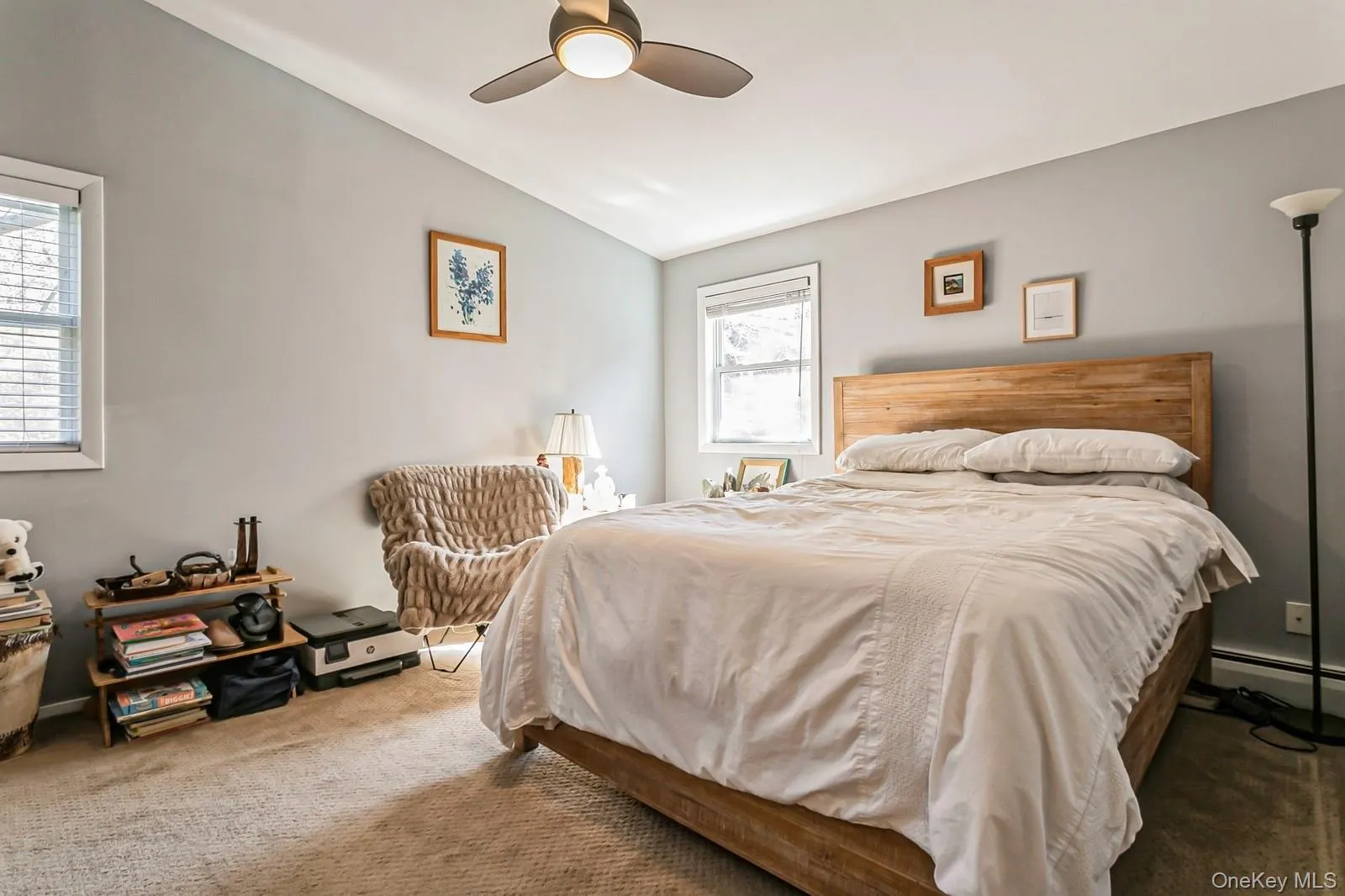 Bedroom with carpet floors, vaulted ceiling, and a ceiling fan Bedroom with carpet floors, vaulted ceiling, and a ceiling fan