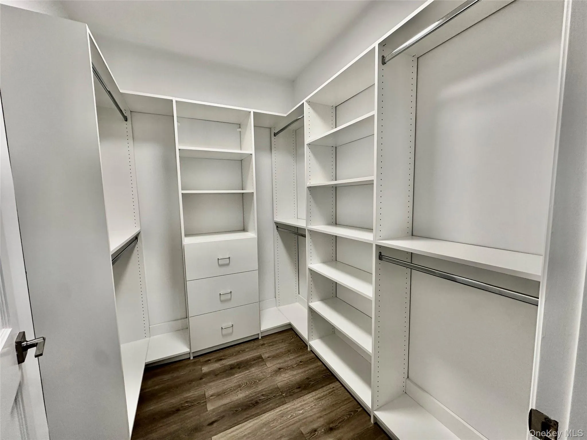 Spacious closet with dark wood-style flooring Spacious closet with dark wood-style flooring