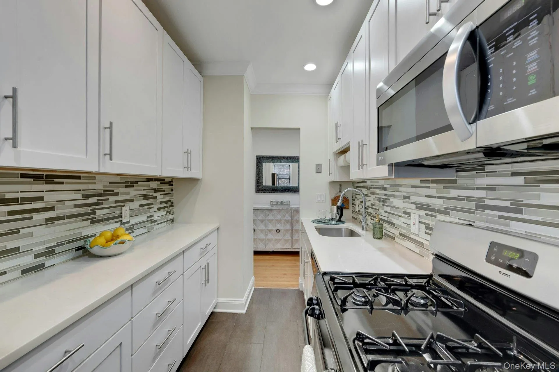 Kitchen with stainless steel appliances, white cabinetry, tasteful backsplash, light stone countertops, and recessed lighting Kitchen with stainless steel appliances, white cabinetry, tasteful backsplash, light stone countertops, and recessed lighting