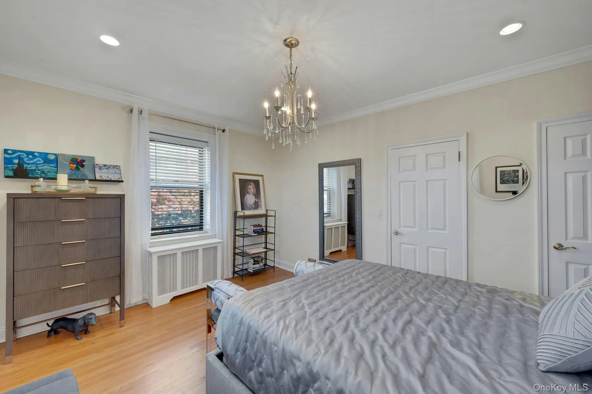 Bedroom with radiator heating unit, ornamental molding, wood finished floors, recessed lighting, and a chandelier Bedroom with radiator heating unit, ornamental molding, wood finished floors, recessed lighting, and a chandelier