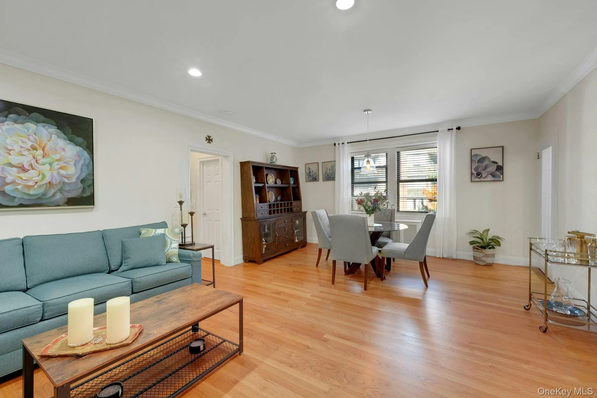 Living area featuring ornamental molding, light wood finished floors, and recessed lighting Living area featuring ornamental molding, light wood finished floors, and recessed lighting