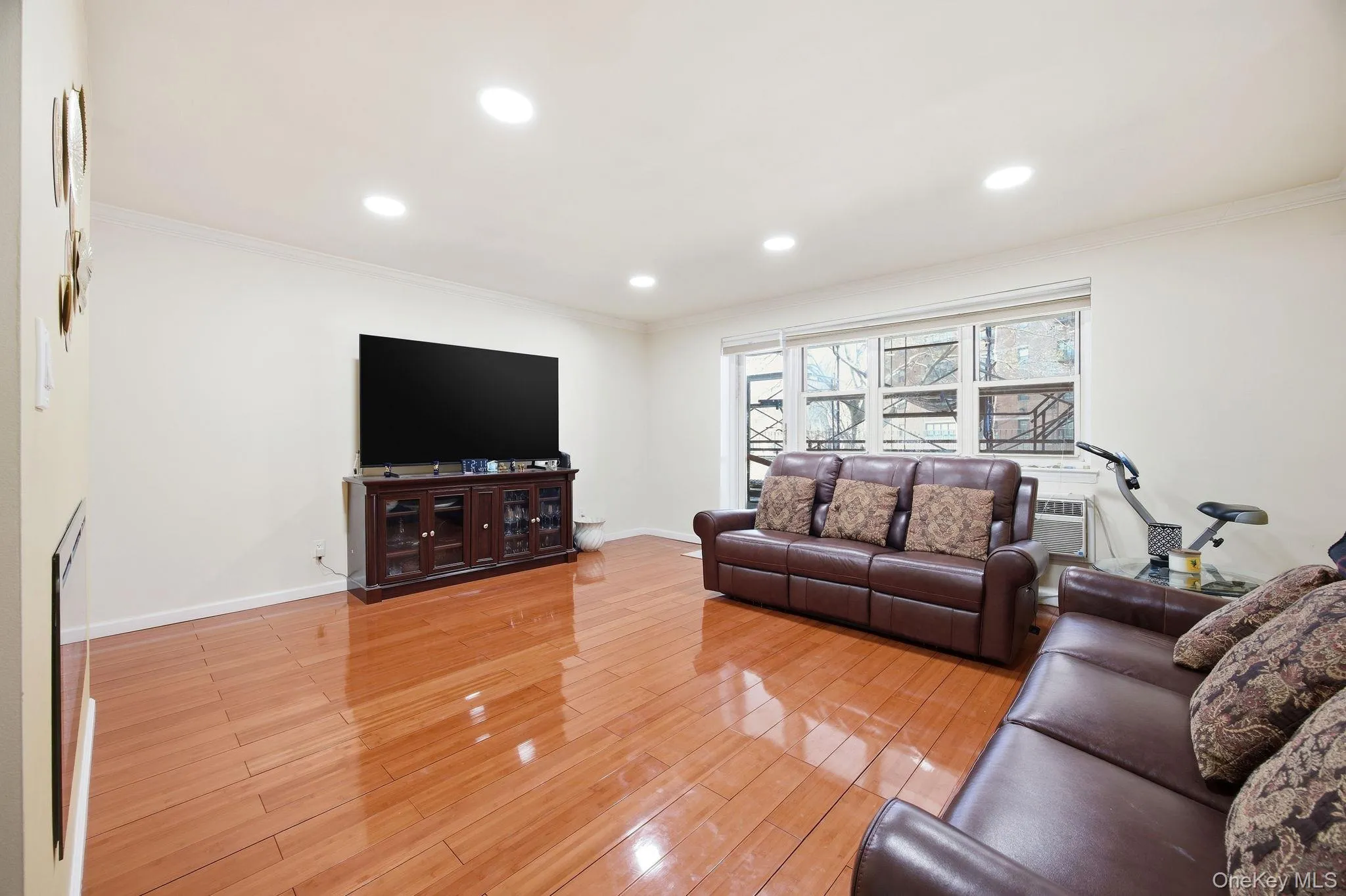Living area featuring light wood finished floors, recessed lighting, and crown molding. Living area featuring light wood finished floors, recessed lighting, and crown molding.