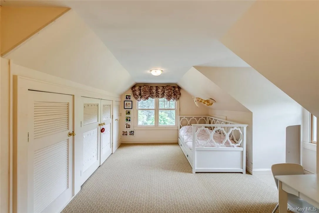 Bedroom featuring lofted ceiling and light colored carpet Bedroom featuring lofted ceiling and light colored carpet