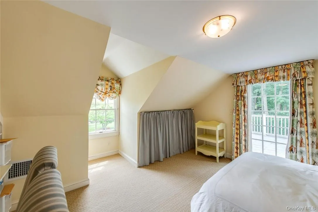 Carpeted bedroom with access to outside and lofted ceiling Carpeted bedroom with access to outside and lofted ceiling