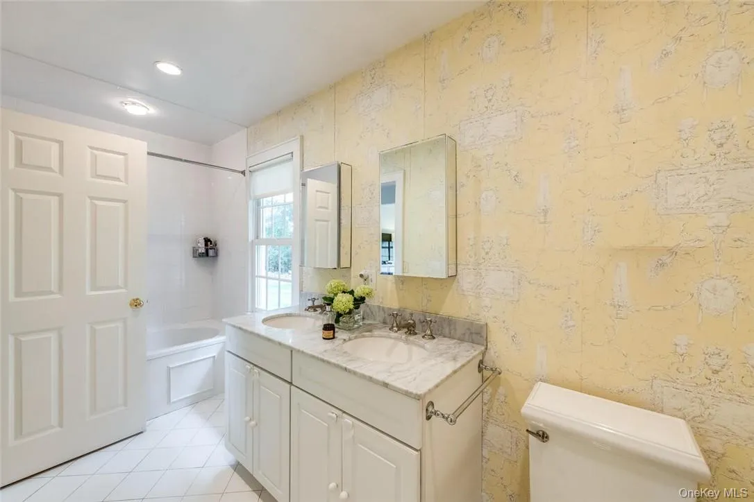 Full bathroom featuring shower / bathtub combination, toilet, vanity, and tile patterned flooring Full bathroom featuring shower / bathtub combination, toilet, vanity, and tile patterned flooring