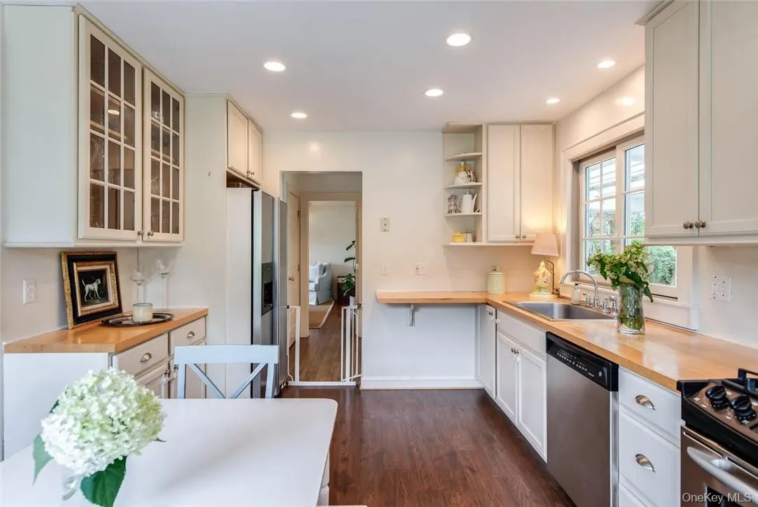 Kitchen with wooden counters, white cabinetry, dark wood-type flooring, stainless steel appliances, and sink Kitchen with wooden counters, white cabinetry, dark wood-type flooring, stainless steel appliances, and sink