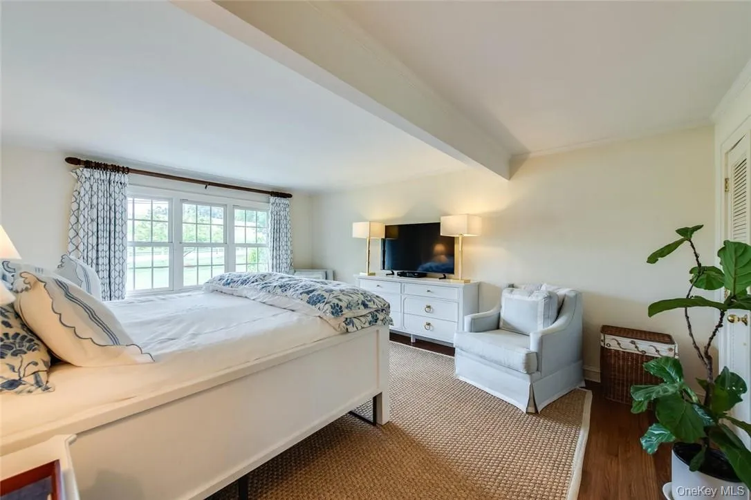 Bedroom with beamed ceiling, hardwood / wood-style flooring, and crown molding Bedroom with beamed ceiling, hardwood / wood-style flooring, and crown molding