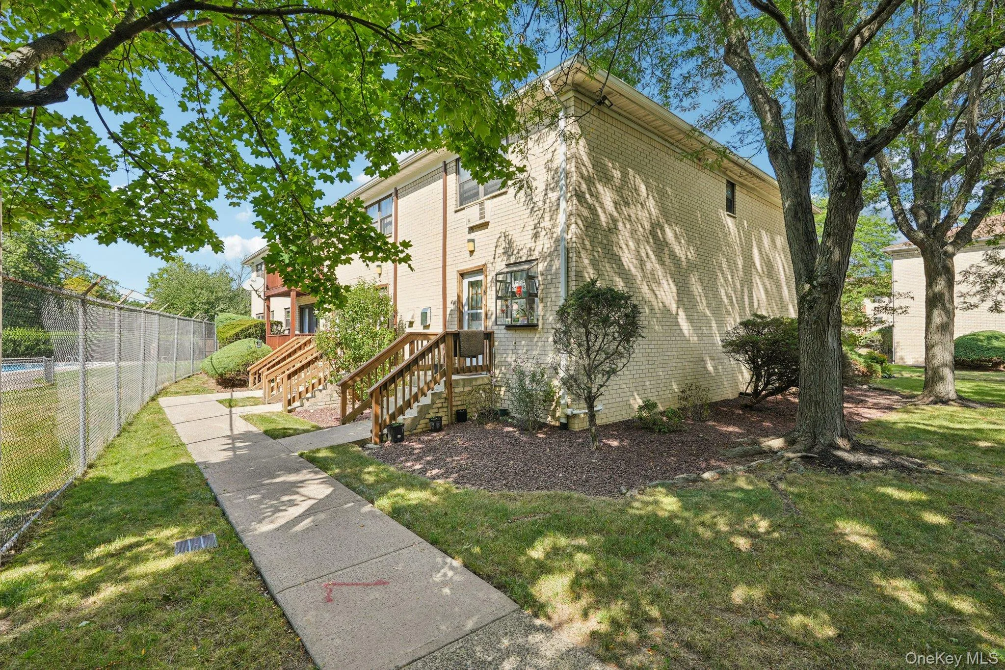 View of side of home with brick siding and a wooden deck View of side of home with brick siding and a wooden deck