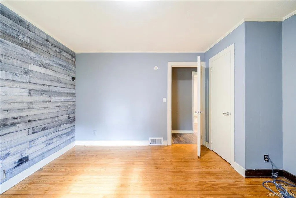 Primary bedroom featuring crown molding and light hardwood / wood-style floors Primary bedroom featuring crown molding and light hardwood / wood-style floors