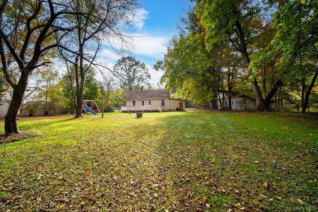 View of yard with a playground and a wooden deck View of yard with a playground and a wooden deck