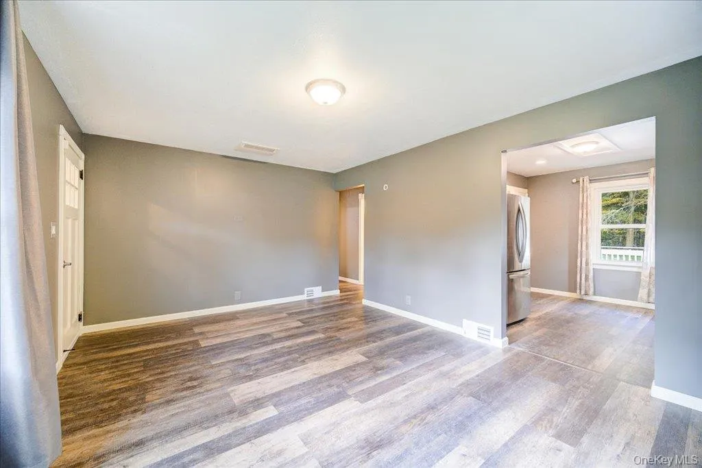 Unfurnished room featuring hardwood / wood-style floors Unfurnished room featuring hardwood / wood-style floors