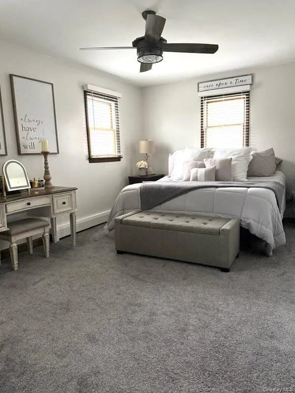 Bedroom featuring carpet flooring, a ceiling fan, and baseboards Bedroom featuring carpet flooring, a ceiling fan, and baseboards
