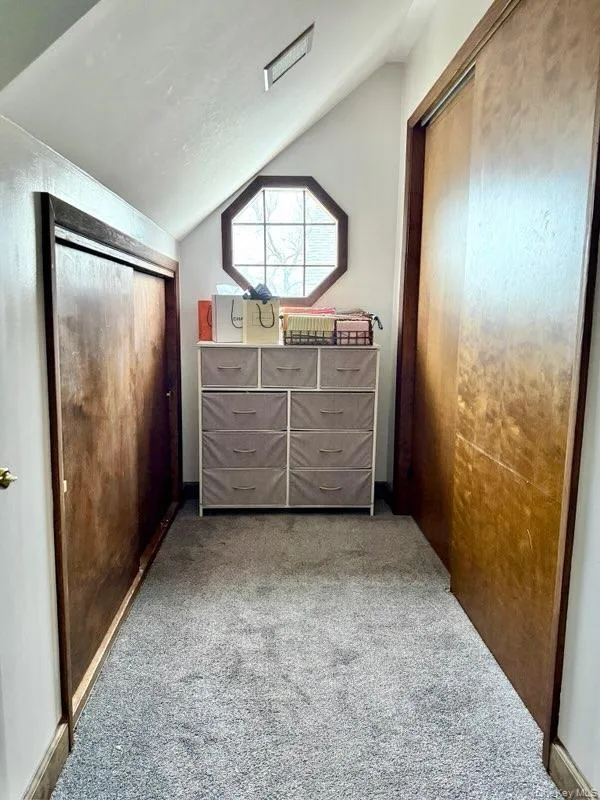 Carpeted bedroom with a closet and vaulted ceiling Carpeted bedroom with a closet and vaulted ceiling