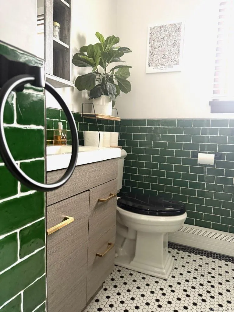 Bathroom with tile patterned floors, wainscoting, toilet, and tile walls Bathroom with tile patterned floors, wainscoting, toilet, and tile walls