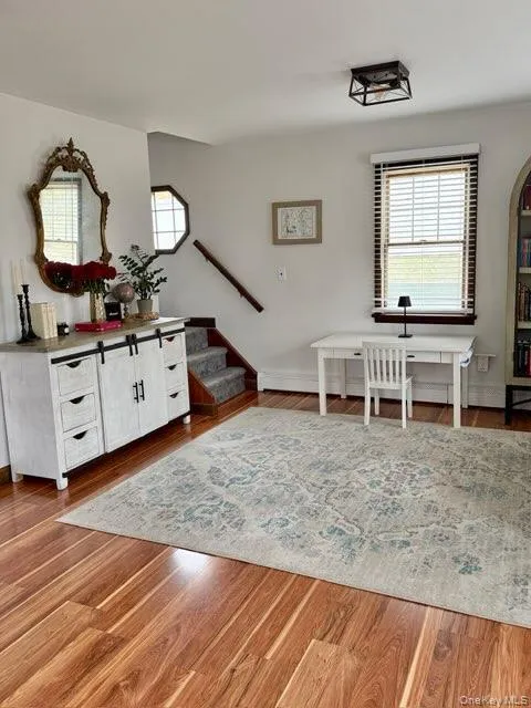 Living room featuring stairs, wood finished floors, and baseboards Living room featuring stairs, wood finished floors, and baseboards