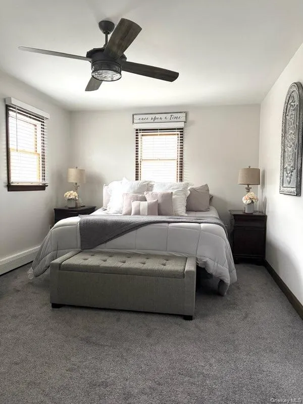 Carpeted bedroom with baseboards and ceiling fan Carpeted bedroom with baseboards and ceiling fan