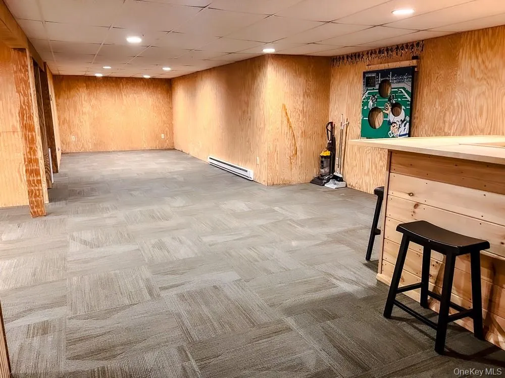 Expansive room featuring recessed lighting, paneled walls, and carpeted flooring Expansive room featuring recessed lighting, paneled walls, and carpeted flooring