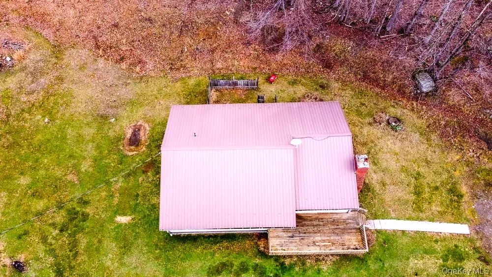 The property features a metal roof, a chimney, and a wooden deck The property features a metal roof, a chimney, and a wooden deck