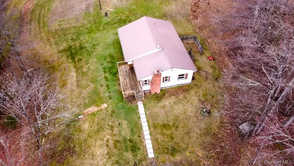 The property features a white exterior with brown shutters and a reddish-brown roof, surrounded by extensive green and brown grounds The property features a white exterior with brown shutters and a reddish-brown roof, surrounded by extensive green and brown grounds