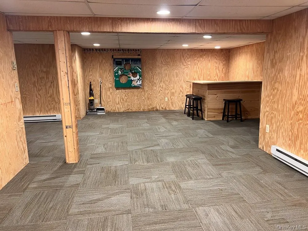 The property features a spacious room with wood paneling, recessed lighting, and carpet tile flooring The property features a spacious room with wood paneling, recessed lighting, and carpet tile flooring