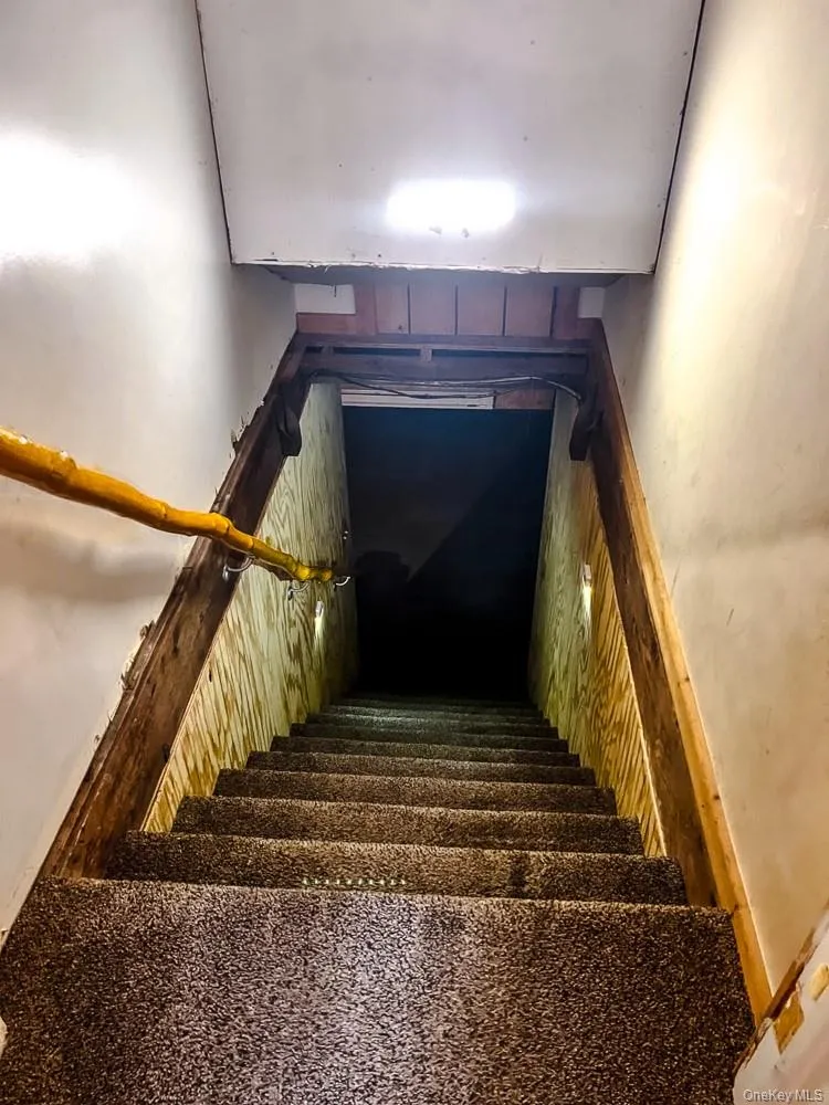 Stairway with carpeted steps and a light fixture on the ceiling Stairway with carpeted steps and a light fixture on the ceiling