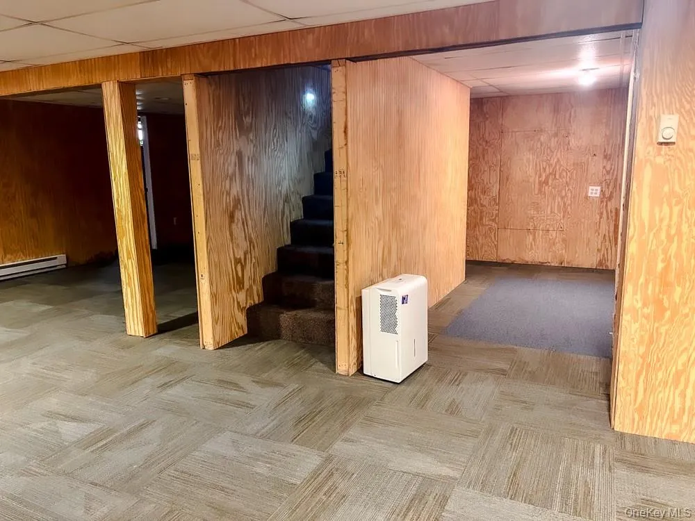 This property features a finished space with wood paneling and patterned carpet flooring This property features a finished space with wood paneling and patterned carpet flooring