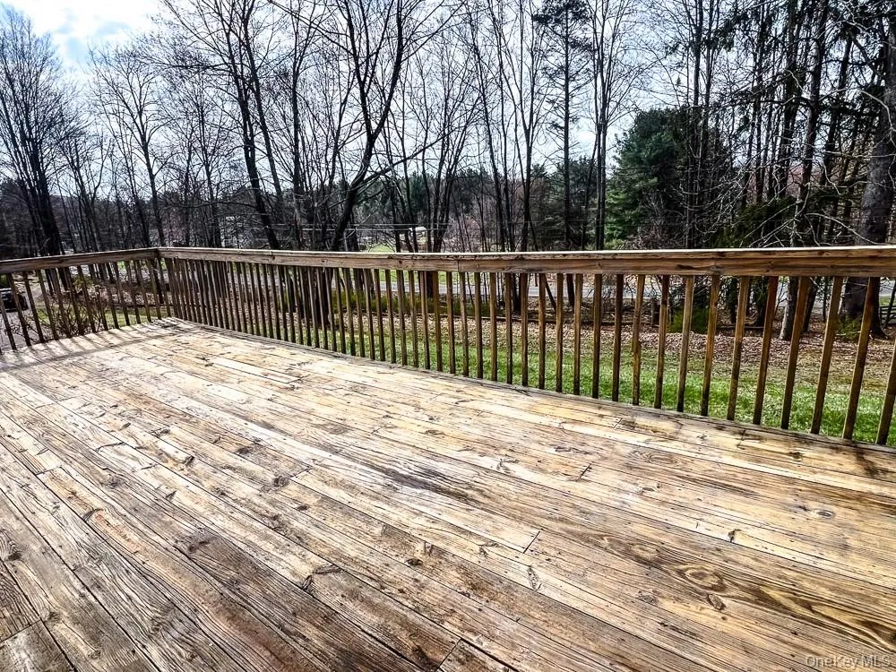 The property features a wooden deck with a railing, overlooking a natural landscape with trees and grass The property features a wooden deck with a railing, overlooking a natural landscape with trees and grass