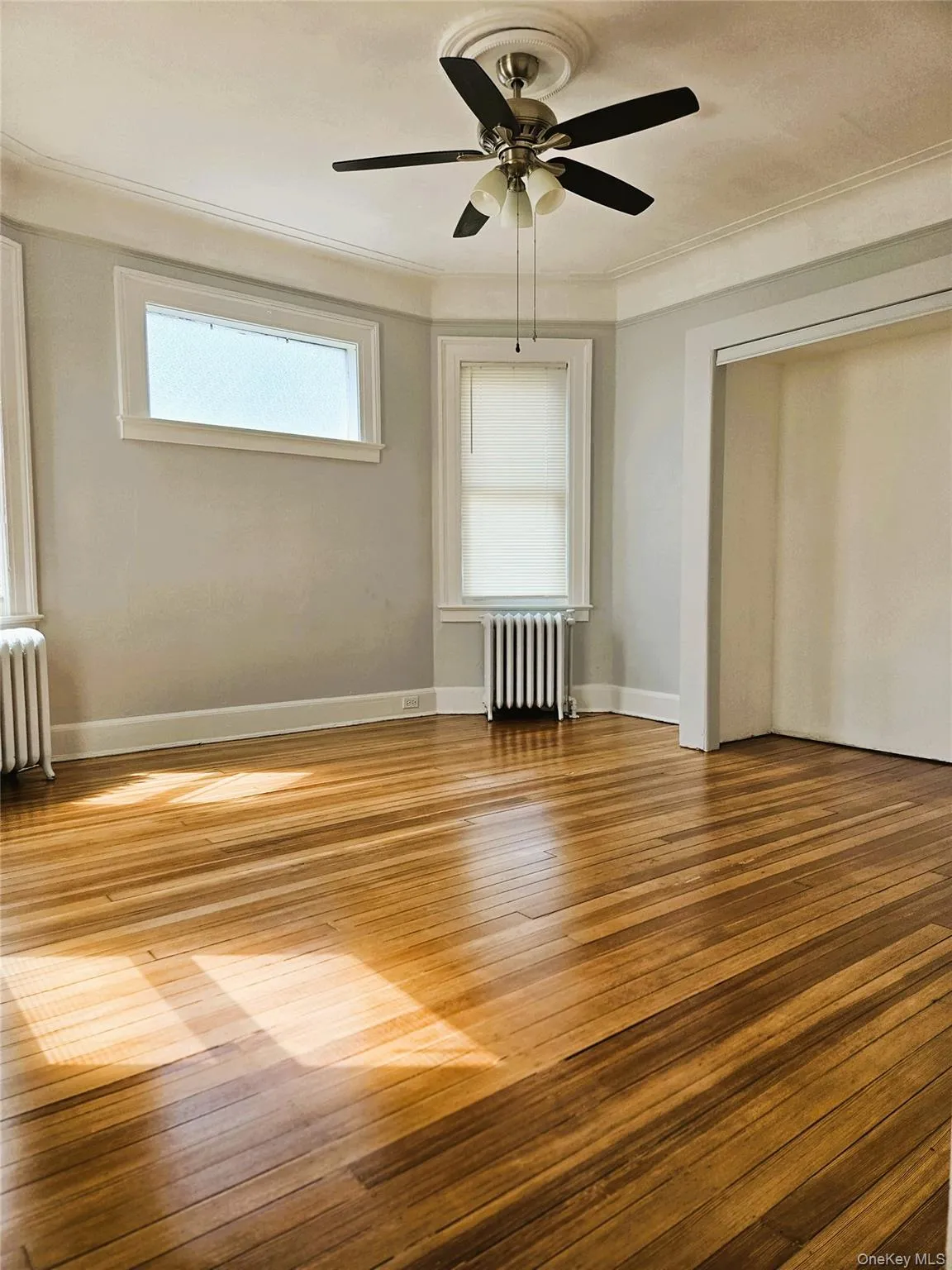 king size bedroom with double mirrored closet, hardwood flooring, ceiling fan king size bedroom with double mirrored closet, hardwood flooring, ceiling fan