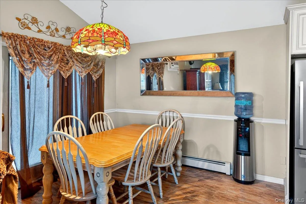 Dining space featuring baseboard heating and dark wood finished floors Dining space featuring baseboard heating and dark wood finished floors