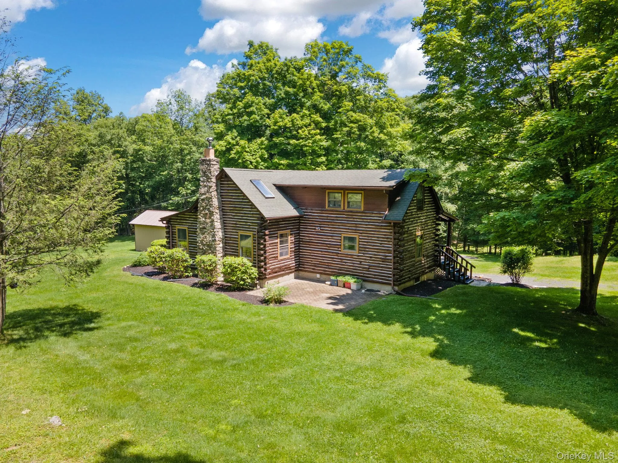 View of front of property with log siding, a chimney, and a front yard View of front of property with log siding, a chimney, and a front yard