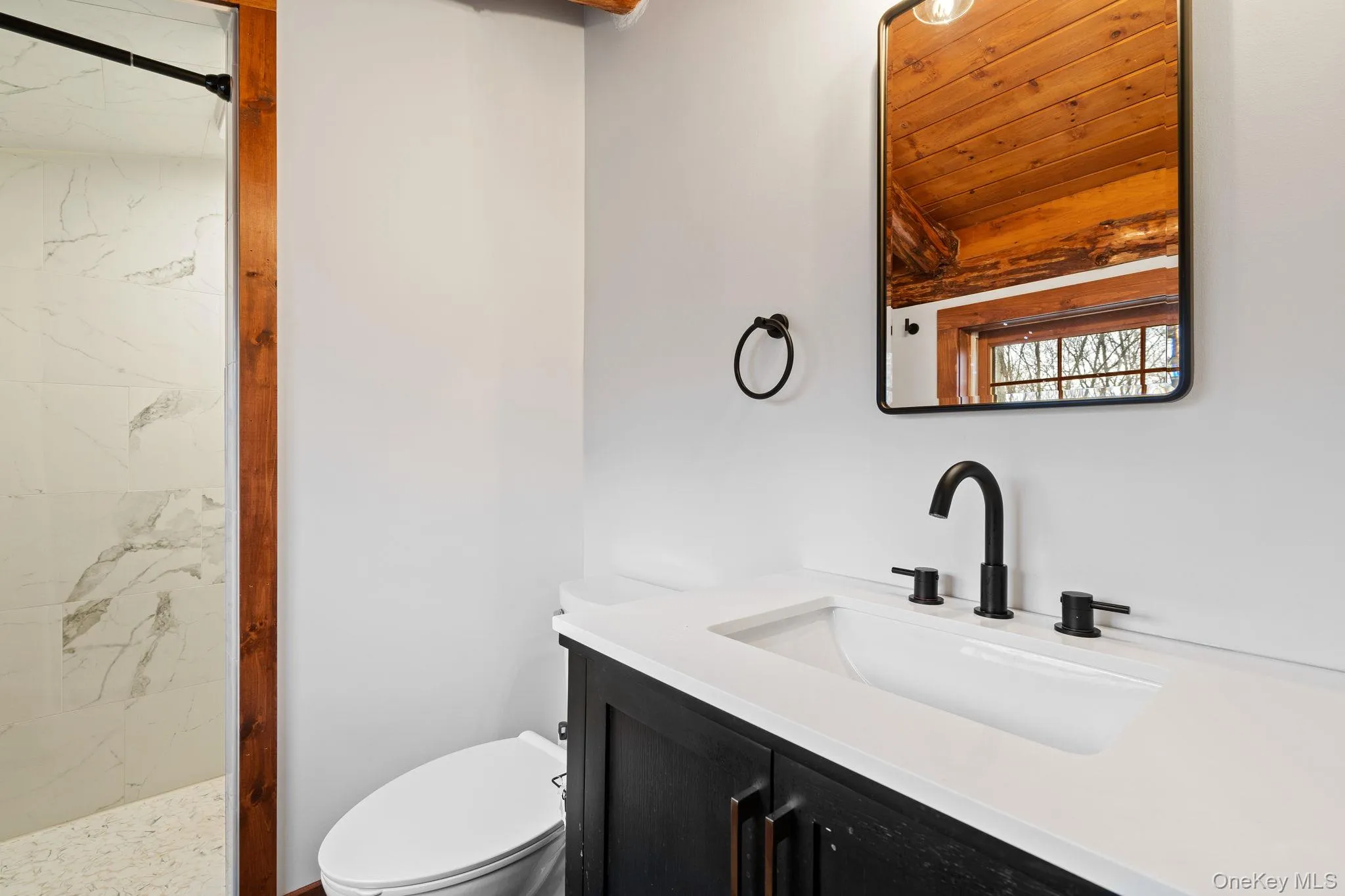 Full bath featuring a marble finish shower and vanity Full bath featuring a marble finish shower and vanity