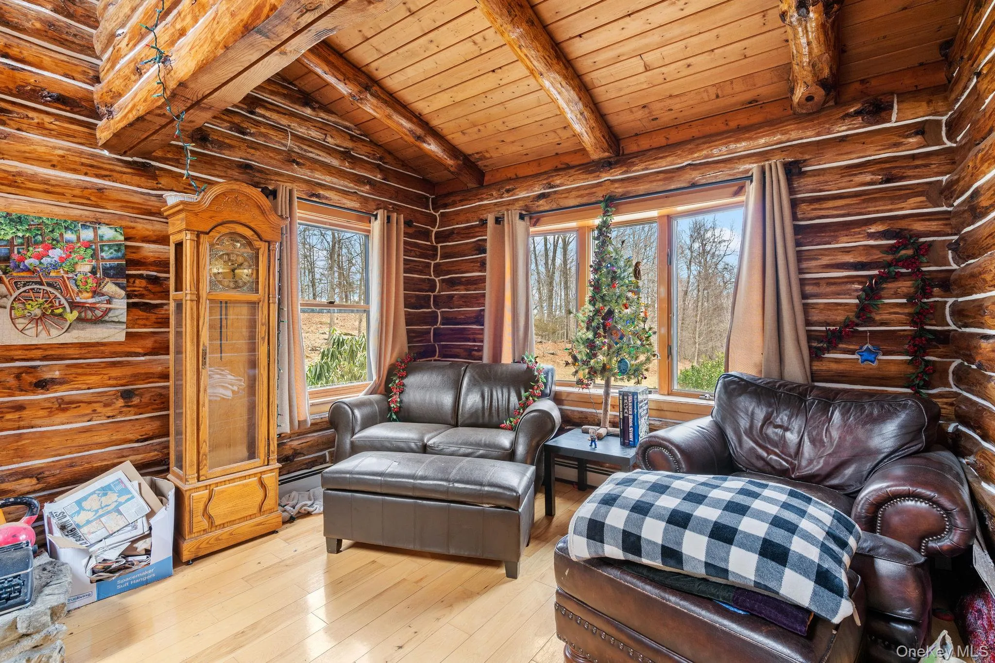 Sitting room featuring wooden ceiling, hardwood / wood-style flooring, and log walls Sitting room featuring wooden ceiling, hardwood / wood-style flooring, and log walls
